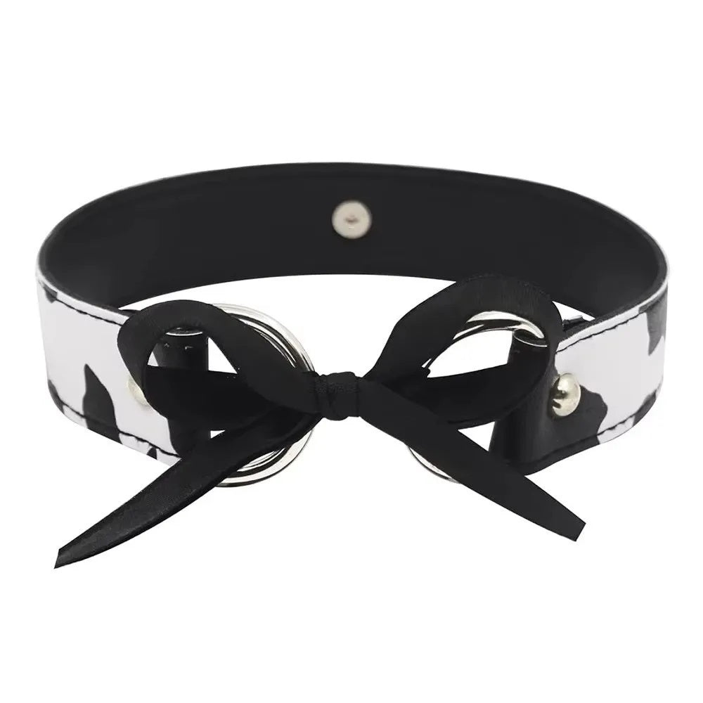 Detailed view of the adjustable ribbon tie and O-ring closure on a cow print collar.
