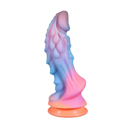 Upright fantasy dragon dildo featuring a dreamy pastel pink, blue, and orange gradient with textured scales and a suction cup base.