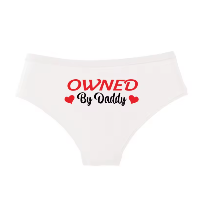 White panties with black text 'OWNED By Daddy' and small red hearts. Cute pet play and possession lingerie.