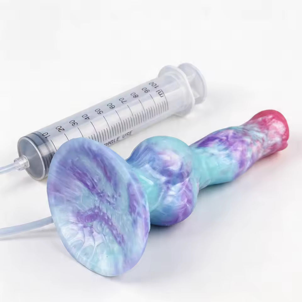 Pastel galaxy swirl marbled squirt dildo lying horizontally, showcasing the flared suction cup base and attached syringe kit.