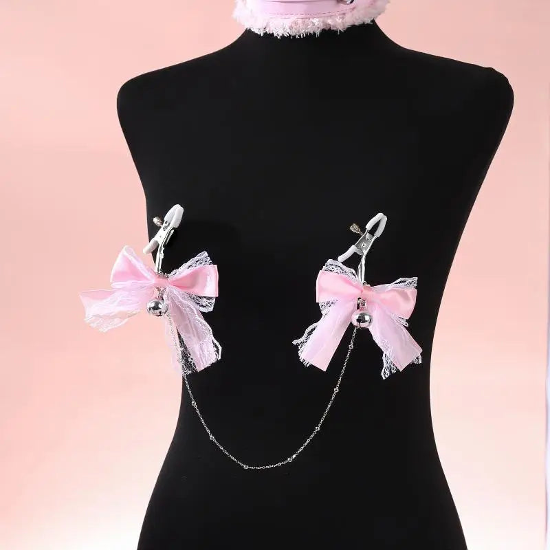 Black mannequin displaying how the sweet pink ribbon nipple clamps and draped silver connecting chain look when worn on the body.