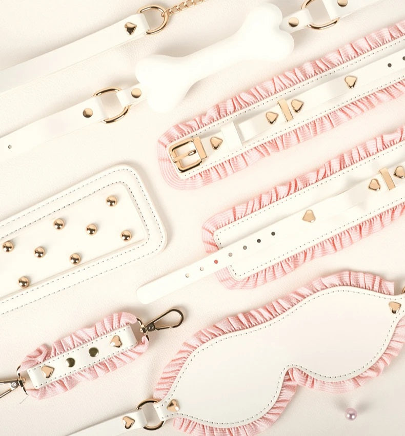 Close-up macro shot highlighting the premium precision stitching, soft white vegan leather, and delicate frayed pink ruffles of the luxury BDSM collection.