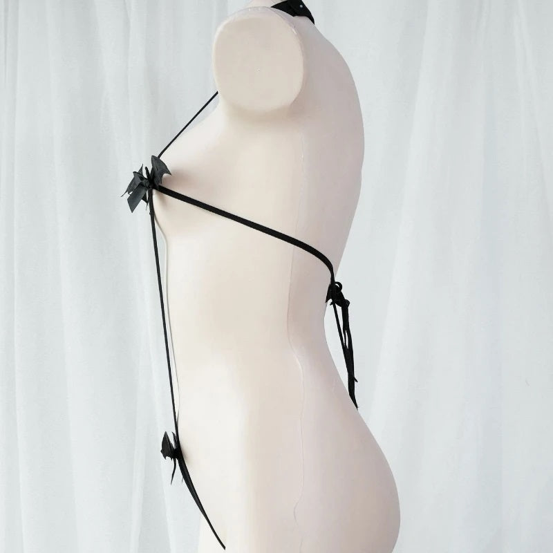 Side angle of an adjustable black elastic monokini harness featuring cute bat and bow details. Alternative goth lingerie