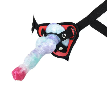 Pastel galaxy swirl fantasy knot dildo attached to a black O-ring strap-on harness for couples pegging play.