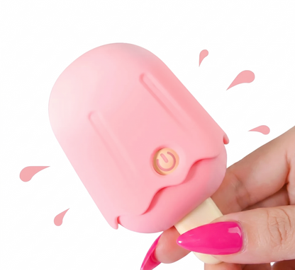 A hand with bright pink nails holding the popsicle-shaped clitoral sucker at an angle, framed by cute cartoon splashing pink droplets against a white background.