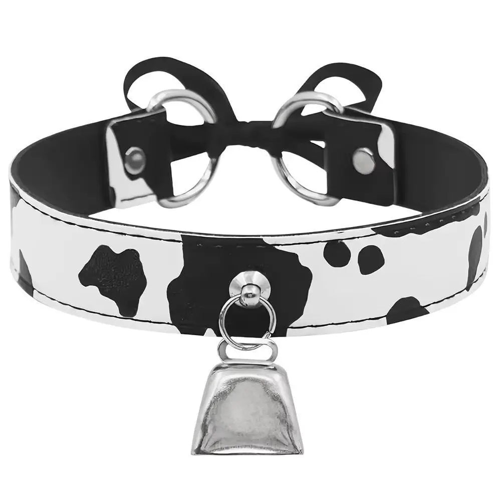 Front view of a cow print kitten play collar featuring a shiny silver bell.