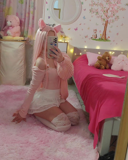 Wide lifestyle shot of a girl in an aesthetic pink bedroom wearing kawaii pet play accessories.