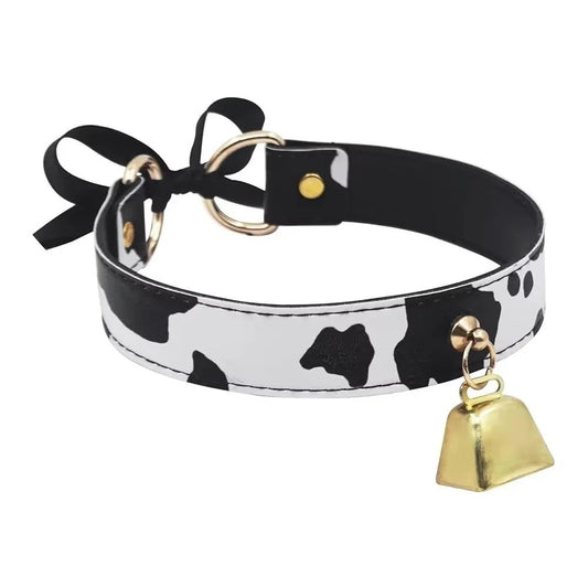 Cow print choker with golden hardware and bell, shown against a white background.