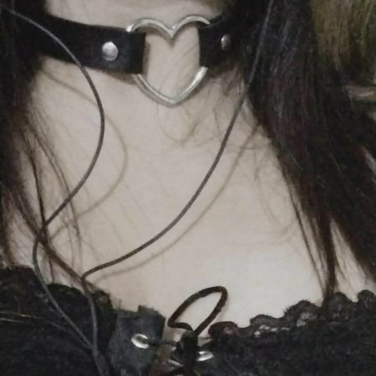 A lifestyle shot of a model in black lace wearing the classic black vegan leather open heart choker.