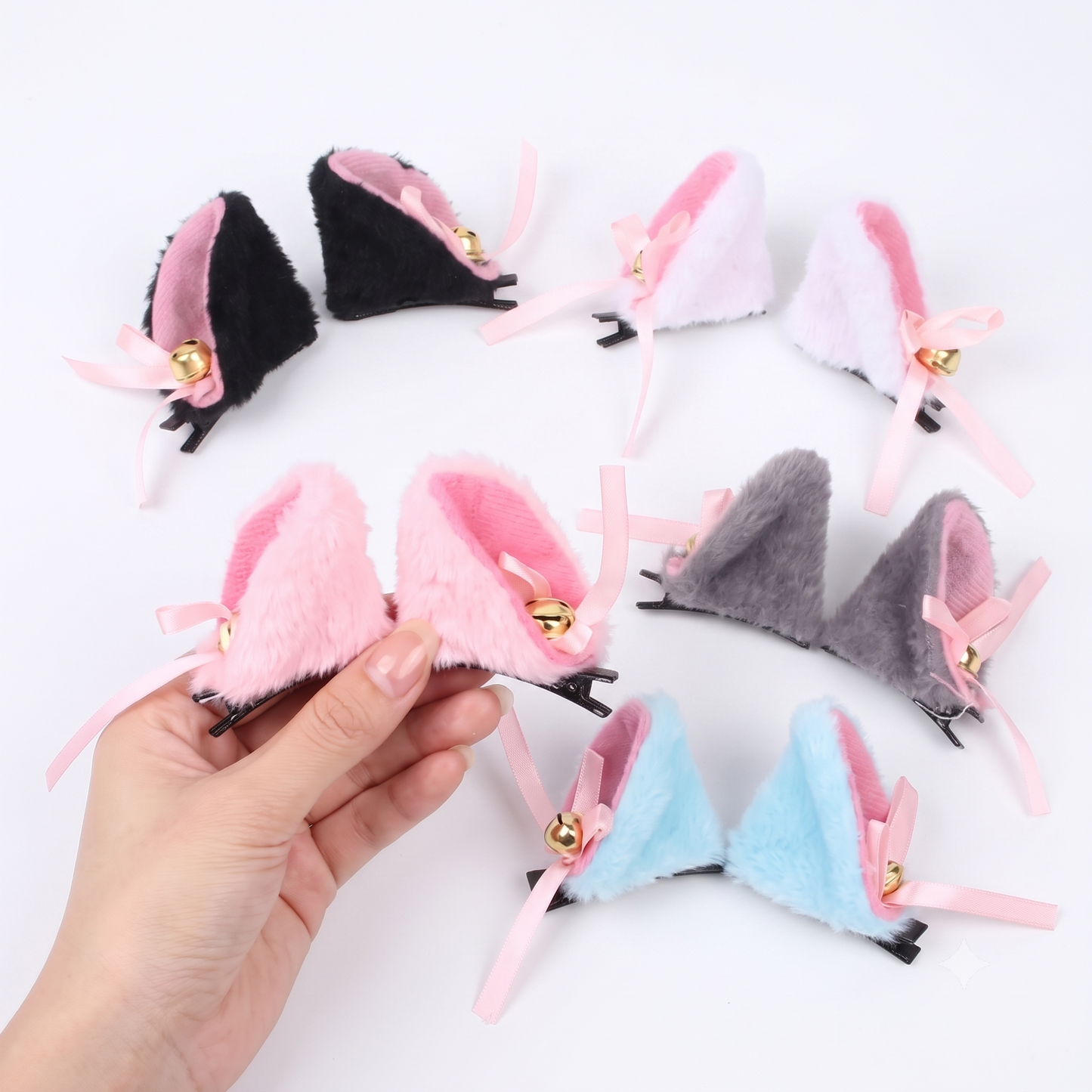 Hand displaying multiple colors of furry cat ear clips with jingling bells.
