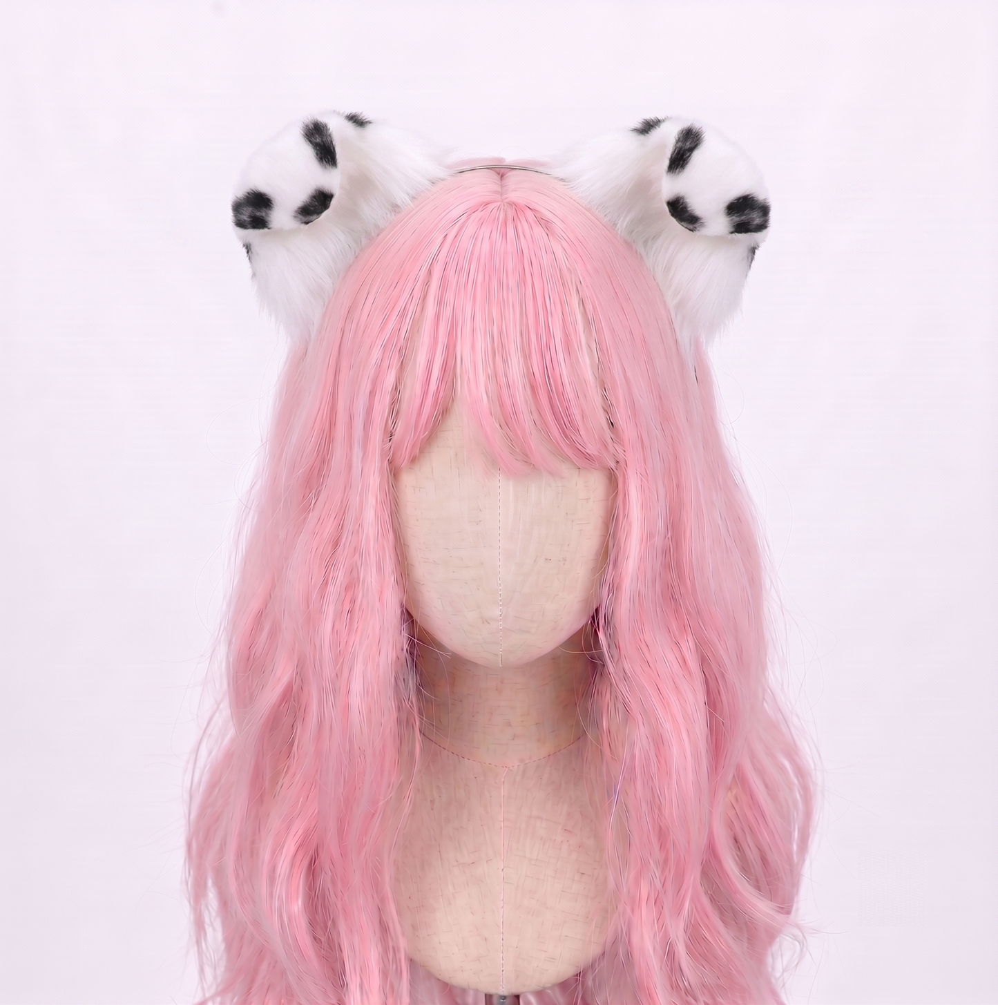 Large main product view of a pale mannequin head with long pastel pink hair wearing a discreet metal headband featuring large, fluffy white faux fur puppy ears with striking black dalmatian spots, perfect for submissive pet play and cosplay.