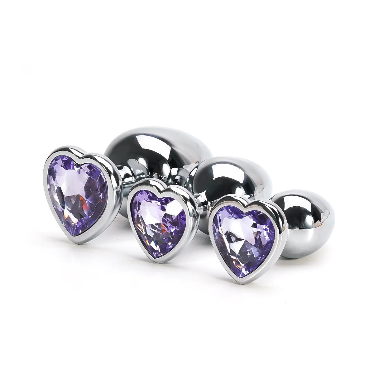 A trio of stainless steel training plugs featuring soft lavender purple crystal heart bases.