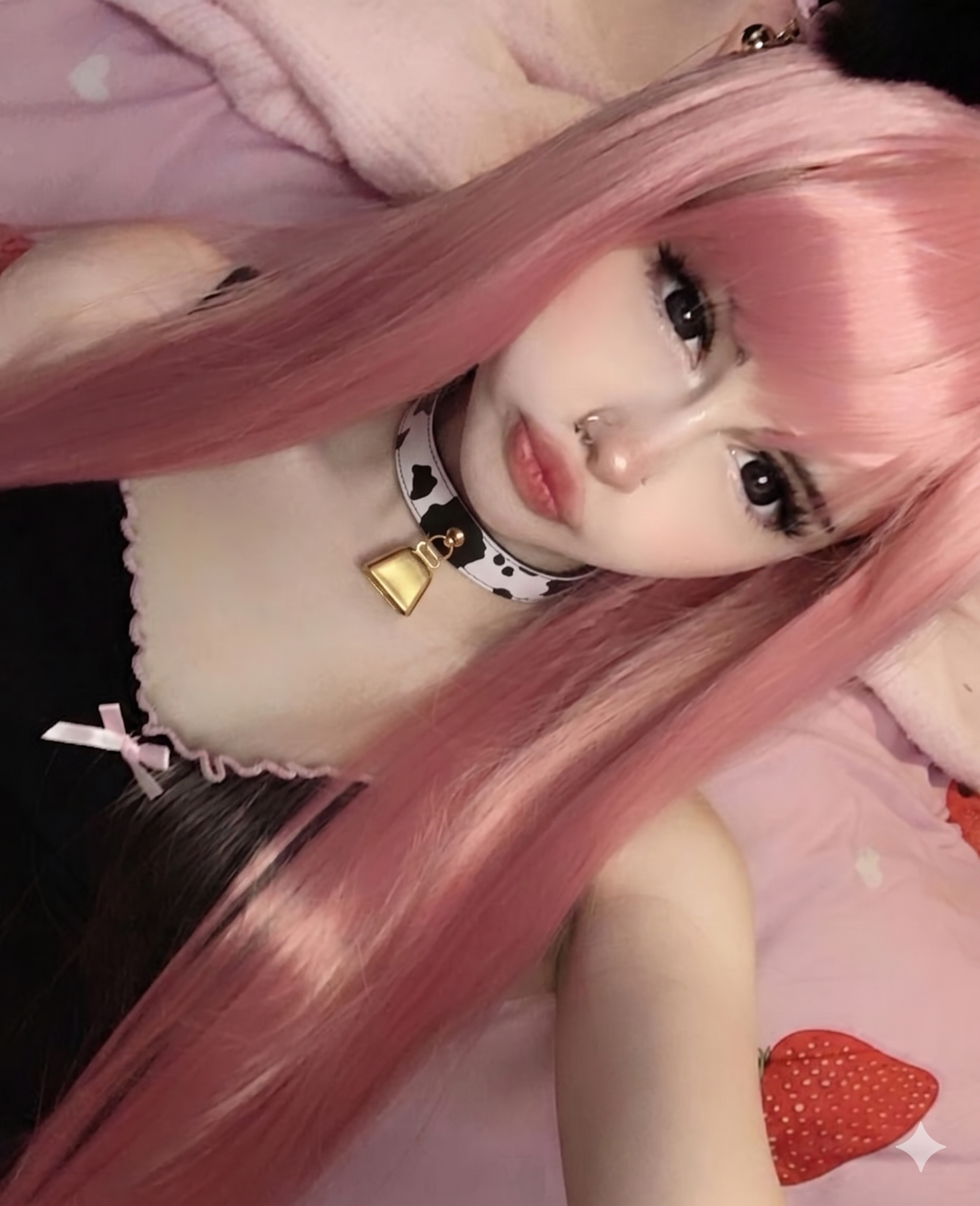 model wearing a Pastel goth accessory: black and white cow print choker with a metallic cowbell.