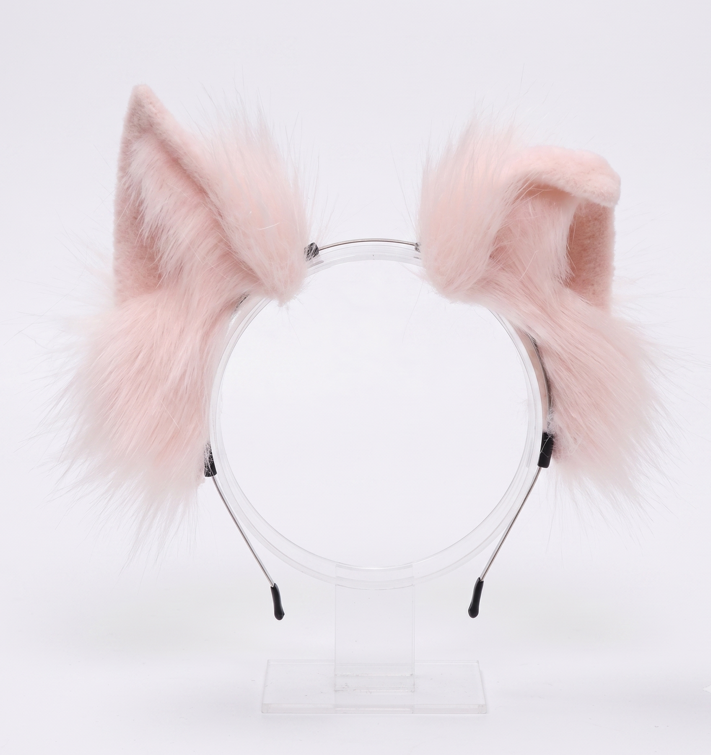 A close-up of incredibly fluffy pastel pink faux fur animal ears securely mounted on a flexible, headache-free headband.