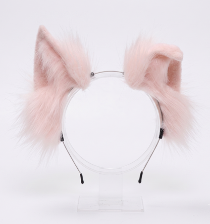A close-up of incredibly fluffy pastel pink faux fur animal ears securely mounted on a flexible, headache-free headband.