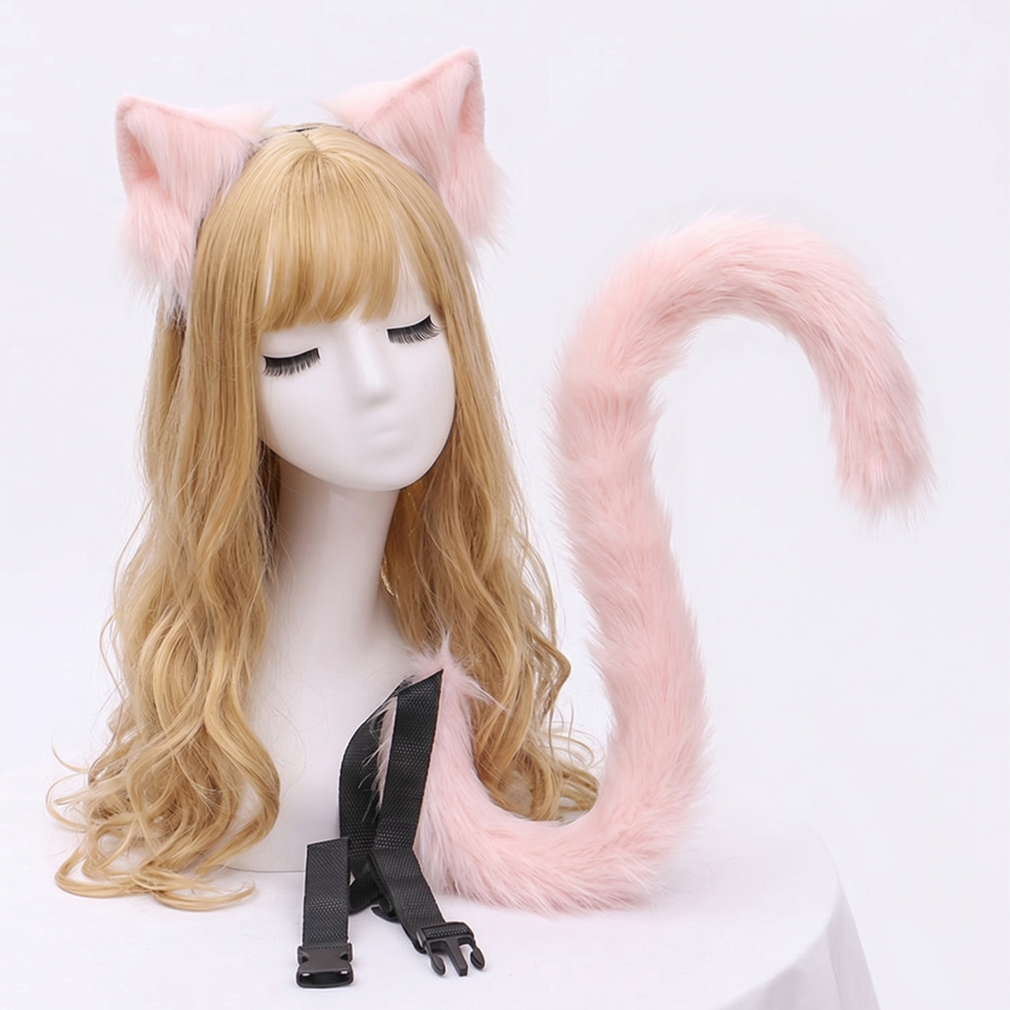 A pastel pink fluffy faux fur ear and long posable tail set designed for SFW pet play, gracefully curled and displayed on a mannequin head.