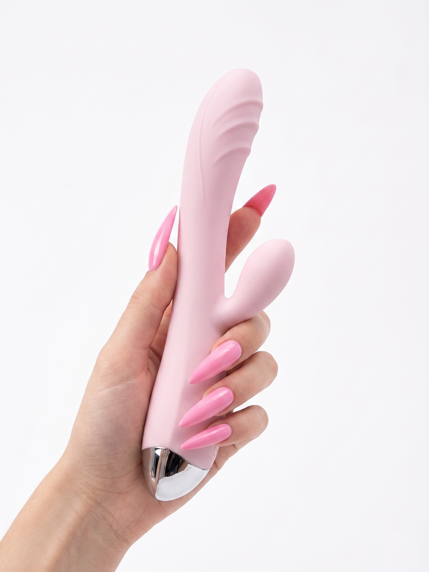 Aesthetic lifestyle shot of a hand with long pink nails holding the velvety baby pink Pastel Dream Rabbit Vibrator.