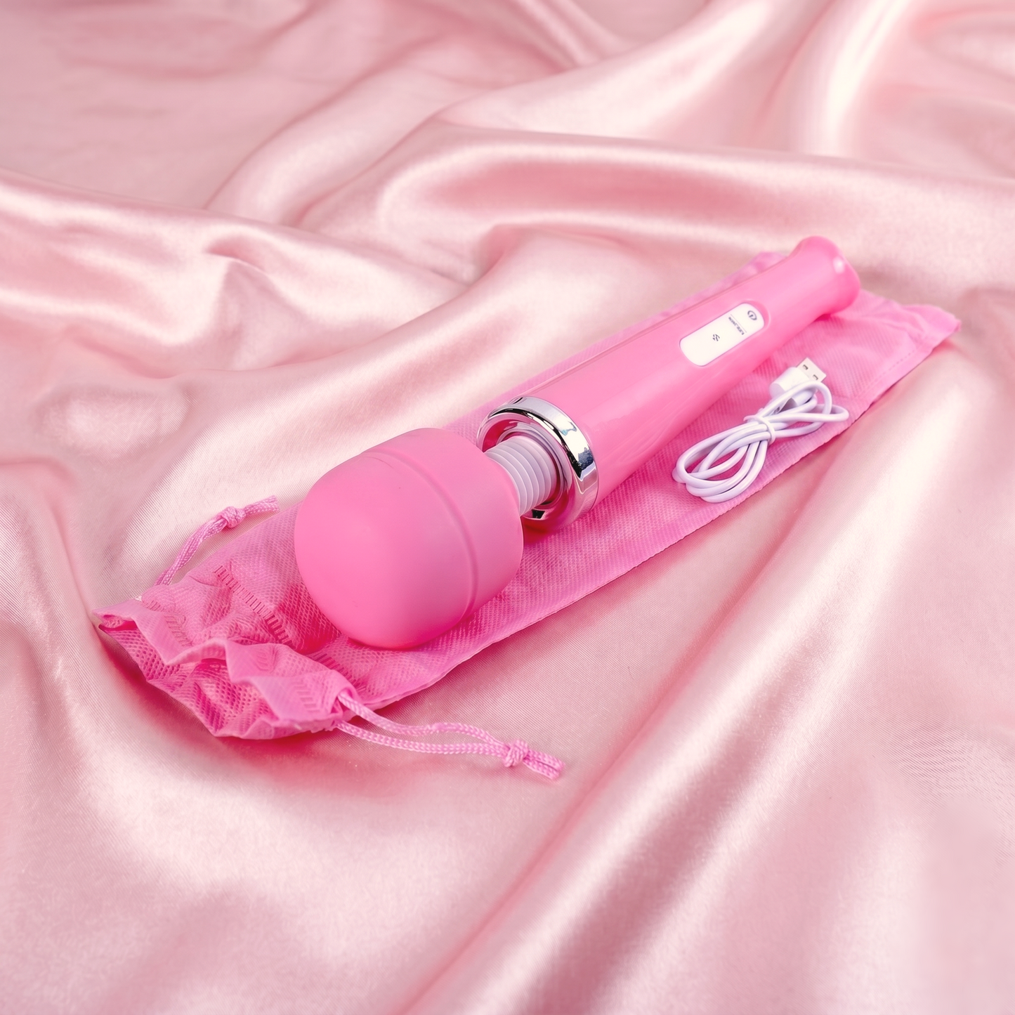 The pink 10-speed wand vibrator resting on its matching pink discreet travel and storage pouch on a luxurious satin background.