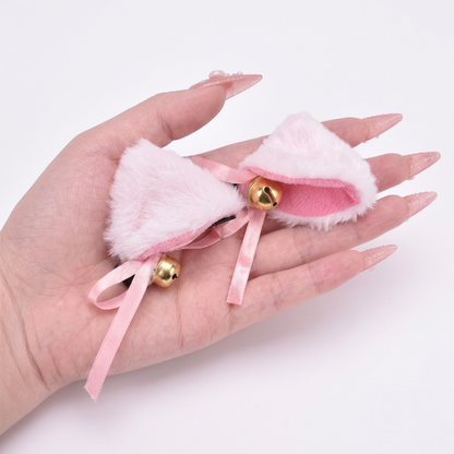 Close-up of a sweet pastel pink furry cat ear resting on a hand.