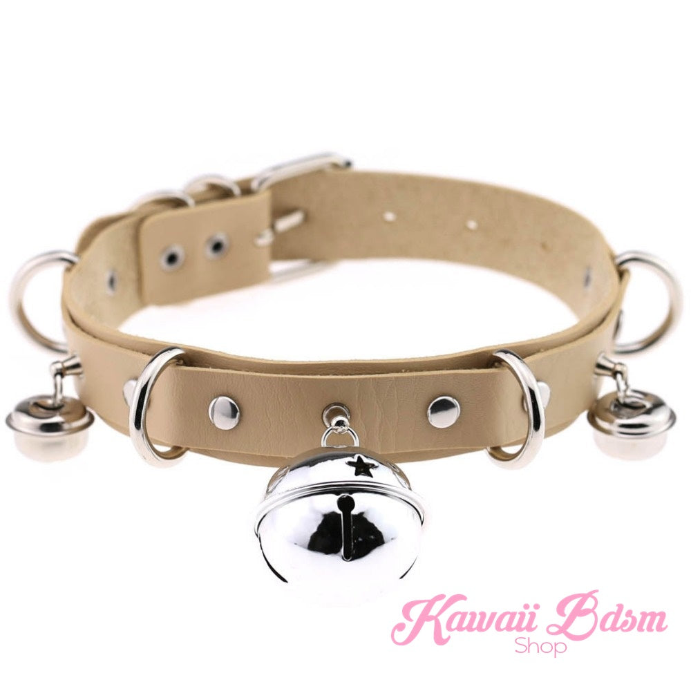 The neutral beige or tan leather cat bell collar variation with shiny silver buckles and a central jingle bell.