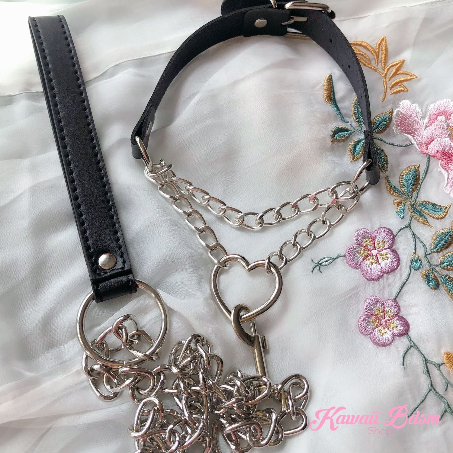 Flatlay display of the premium black leather chain heart choker with its matching black leather submission leash set and silver hardware.