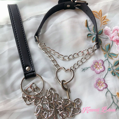 Flatlay display of the premium black leather chain heart choker with its matching black leather submission leash set and silver hardware.