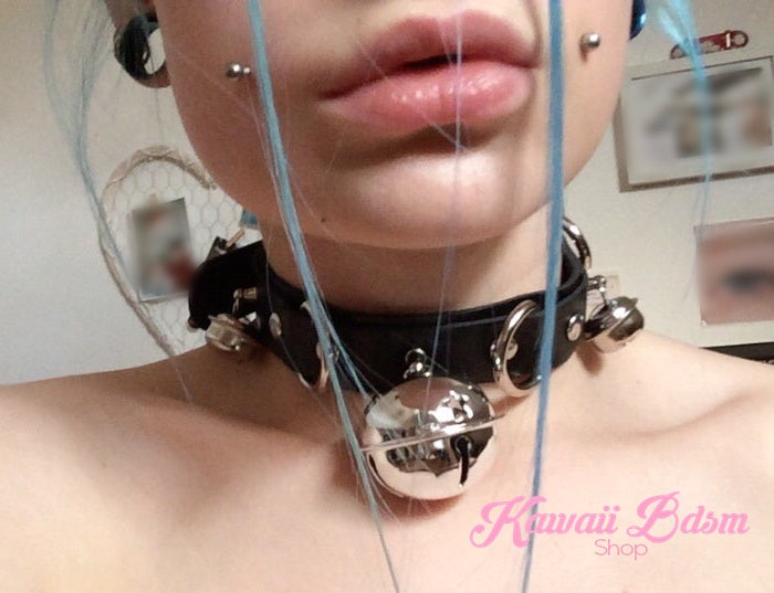 Close-up shot of a model wearing the black leather kitty cat bell collar choker, showcasing its cute alt-fashion and kinky aesthetic.
