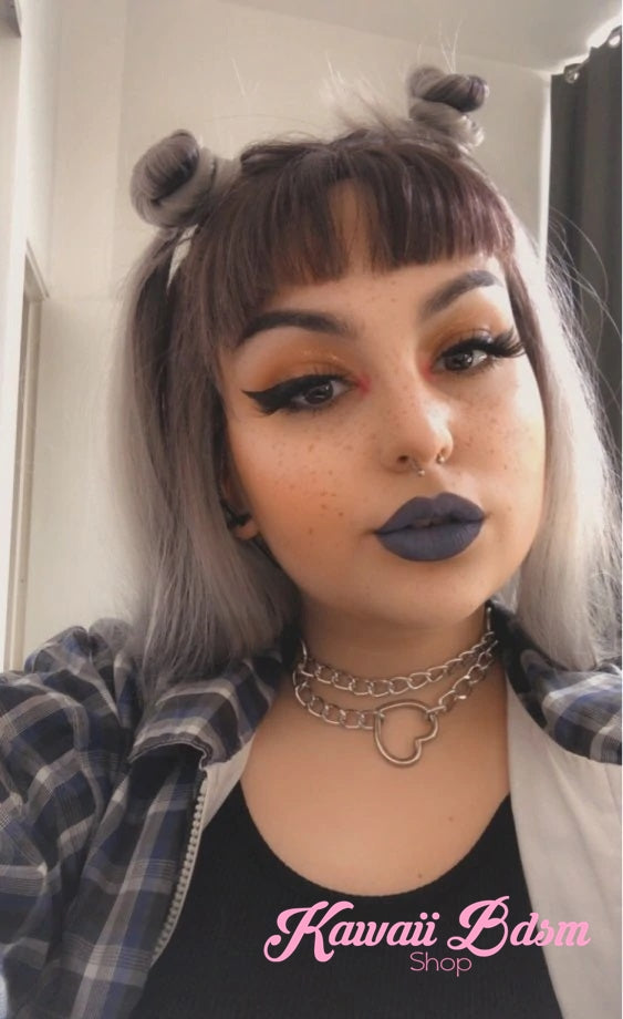 A model with space buns hair wearing the silver chain heart choker collar, showcasing a cute kawaii bondage look.