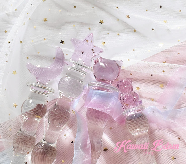 Close-up view of assorted cute glass wands, including the teddy bear handle, lying on a dreamy pastel fabric.