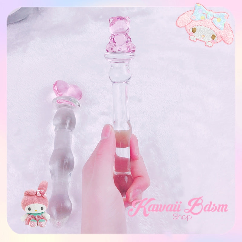 Hand holding the kawaii teddy bear glass wand against a soft pink and purple aesthetic background with cute graphics.