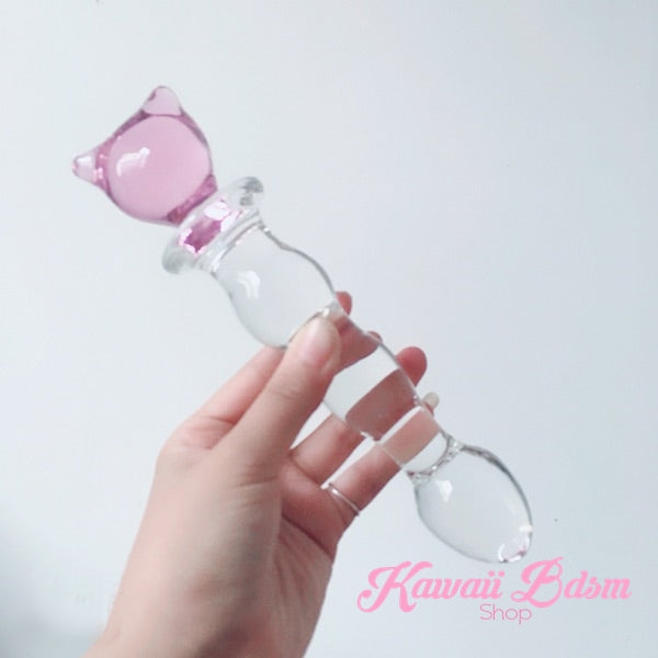 Hand holding the kawaii pink kitty glass wand at an angle against a soft pastel background, showing its ergonomic grip.