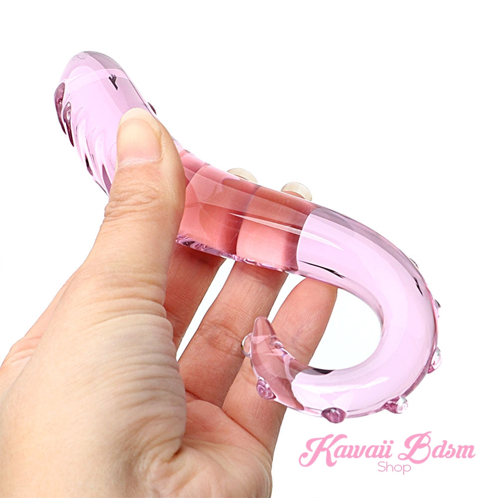 Close-up of a hand holding the slender pink glass tentacle toy, showing its gentle curve and smooth hook.