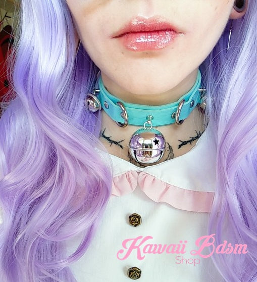 A model with purple hair wearing the pastel light blue leather kitty cat bell collar, highlighting its kawaii submissive vibe.