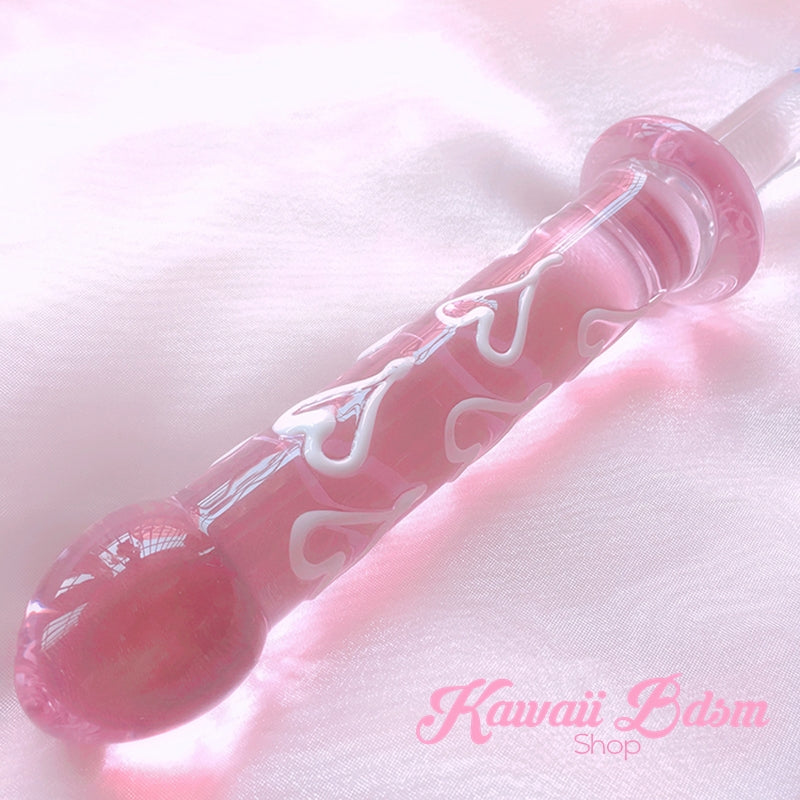 The double ended glass dildo resting diagonally on dreamy pink silk, highlighting its kawaii aesthetic.