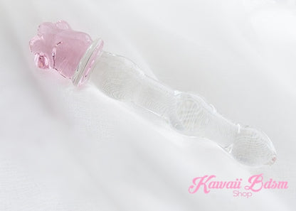 Kawaii glass paw wand resting on white fabric, highlighting the smooth ribbed texture and adorable pink paw base.