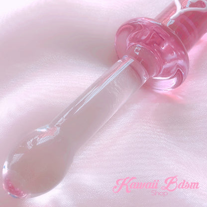 Close-up view of the textured pink glass end of the dildo, showing the adorable raised white heart details for extra stimulation.