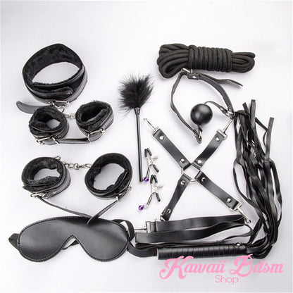 Close-up of the black flogger, feather tickler, and adjustable nipple clamps included in the 10-piece set.