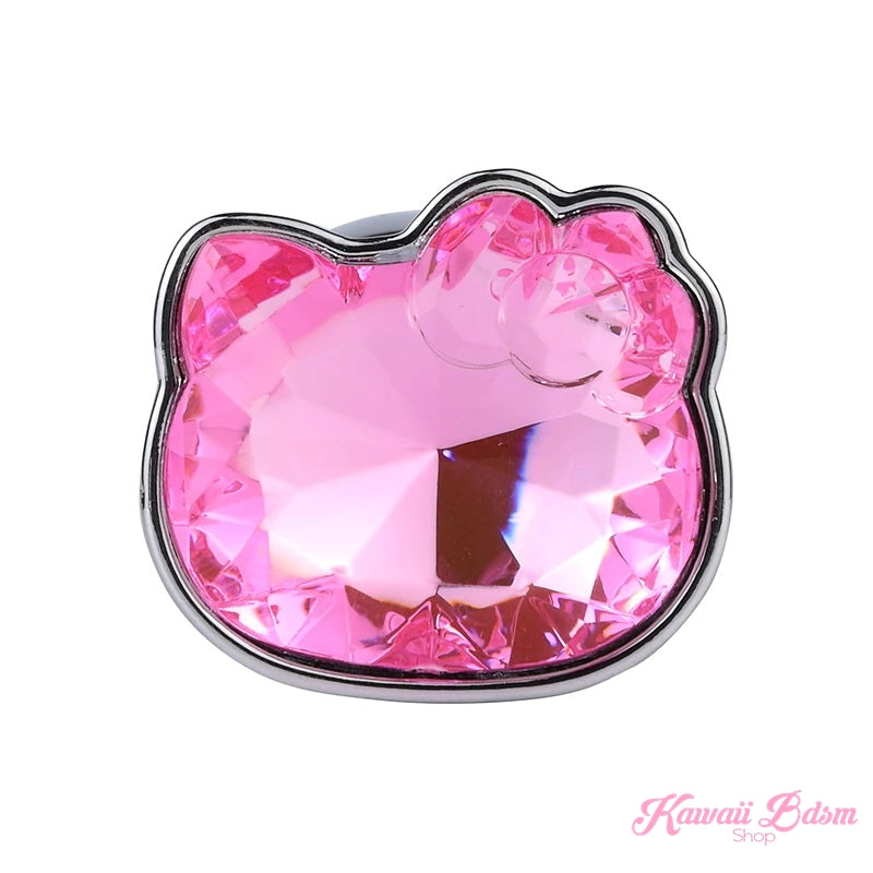 Direct front view of the shiny, faceted pink crystal shaped exactly like a Hello Kitty head on the plug's flared base.