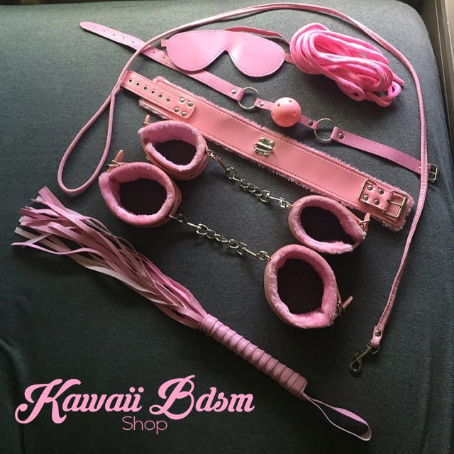 Aesthetic lifestyle shot of the pink BDSM kit with soft plush lining on the handcuffs and collar.