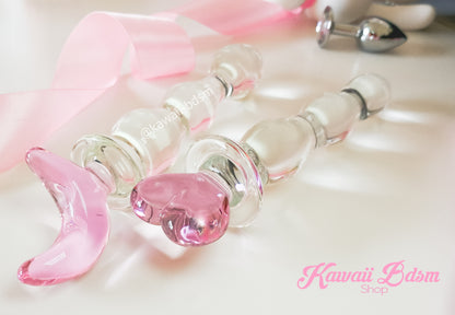 Close-up of the translucent pink glass moon handle with a decorative satin ribbon.