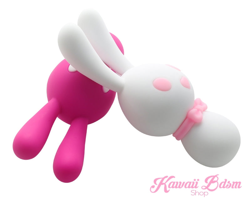 A bright pink Mitzi kawaii bunny vibrator with white bendable ears and a white bow tie, angled to show its ergonomic wand shape
